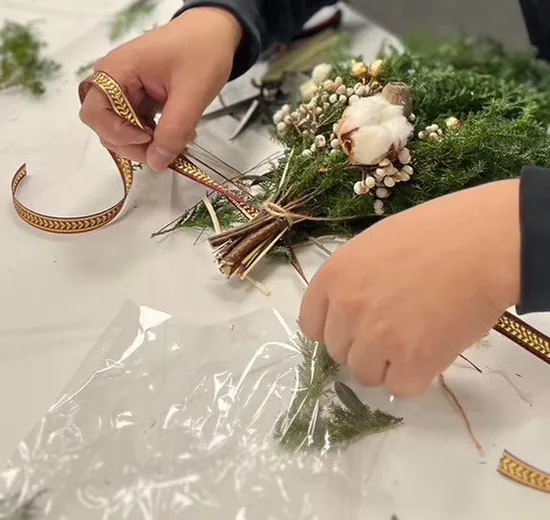 學員雙手在為雪松小花束綁上緞帶